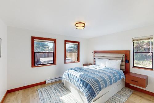 une chambre avec un lit et deux fenêtres dans l'établissement Noyes Retreat, à Sea Ranch