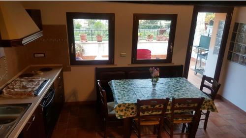 a kitchen with a table and chairs and two windows at La chiave dei tre Abruzzi in Popoli