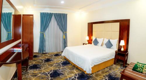 Habitación de hotel con cama y escritorio en فندق لمسات نجران en Najrán