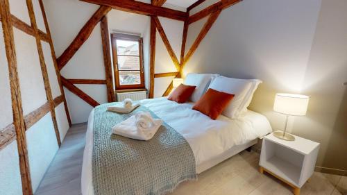 une chambre avec un lit avec des serviettes dessus dans l'établissement La balade de Molly, à Colmar