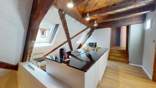 - une cuisine mansardée avec poutres apparentes et parquet dans l'établissement La balade de Molly, à Colmar