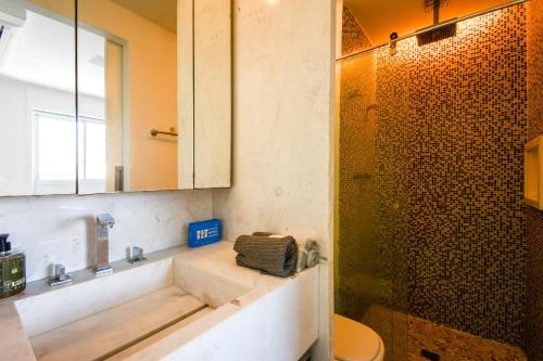 a bathroom with a sink and a shower at Çiragan Apartments by BnbHost in Sao Paulo