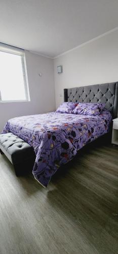 sypialnia z łóżkiem z fioletową kołdrą w obiekcie pacifico 3100 w mieście La Serena