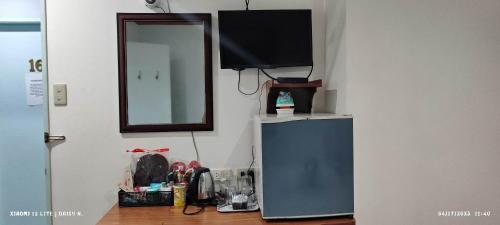 a television on top of a dresser next to a mirror at duck inn manila in Manila