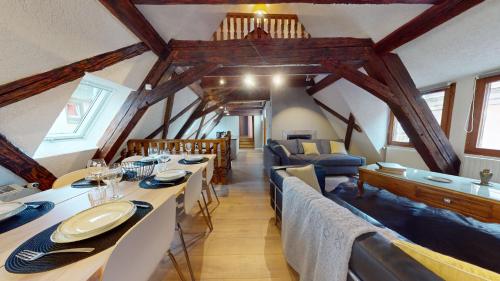 une salle à manger avec une grande table et un salon dans l'établissement La balade de Molly, à Colmar