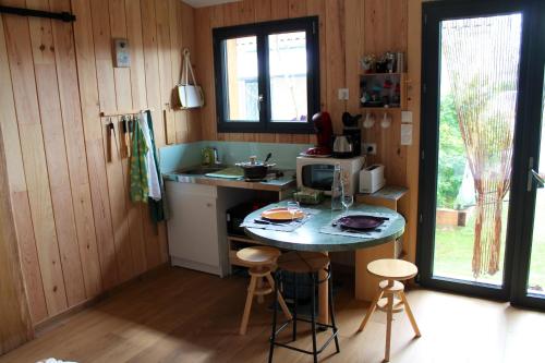 una pequeña cocina con mesa y microondas en Bungalow d'une chambre avec jardin clos et wifi a Ares a 3 km de la plage, en Arès