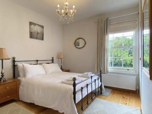 a bedroom with a bed and a window at Green Cottages in Sittingbourne