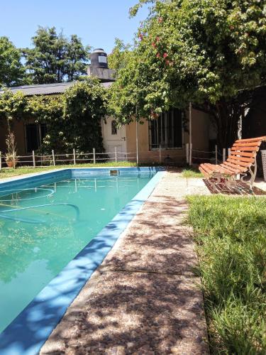 einen Pool mit einer Bank und einem Haus in der Unterkunft Casa Redonda in Monte Grande