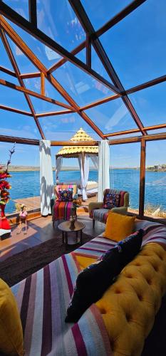 a living room with a couch and a view of the ocean at Glamping Titicaca Perú in Puno