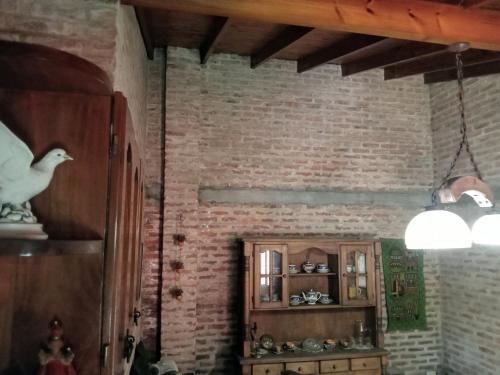 ein Wohnzimmer mit einer Ziegelwand und einem Regal in der Unterkunft Casa Redonda in Monte Grande