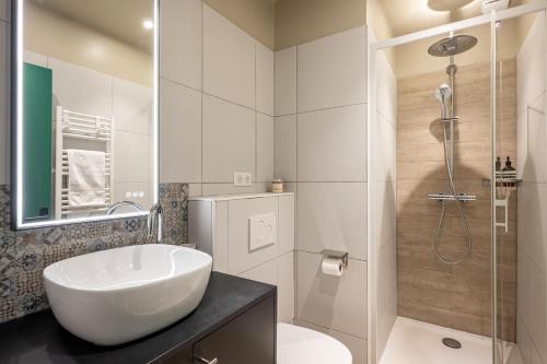 une salle de bain blanche avec un lavabo et une douche dans l'établissement The Green Loft - Eiffel Tower - Paris 15, à Paris