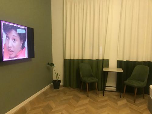 a room with two chairs and a tv on the wall at Aparthotel Old Avenue in Tbilisi City
