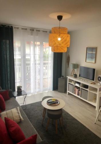 ein Wohnzimmer mit einem Sofa und einem Tisch in der Unterkunft Azurea - Charmant appartement à Andernos-les-Bains in Andernos-les-Bains
