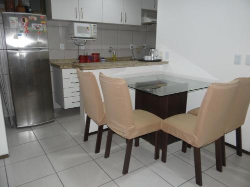 a kitchen with a table and chairs and a refrigerator at Ocean Atlantic Praia de Iracema in Fortaleza