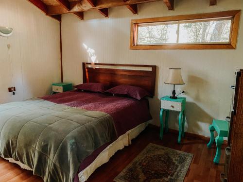 Un dormitorio con una cama grande y una ventana en Cascadas del Llaima, en Refugio Llaima