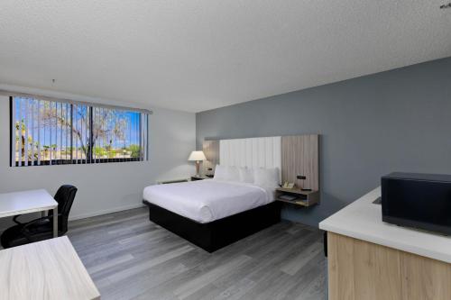Studio 6 Suites Lake Havasu City AZ في مدينة ليك هافاسو: غرفة فندقية بسرير وتلفزيون بشاشة مسطحة