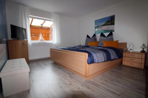 a bedroom with a bed and a television in it at Ferienwohnung Schwallmann in Wilnsdorf