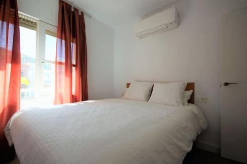 a bedroom with a white bed and a window at Yamato Apartment Albir in Albir