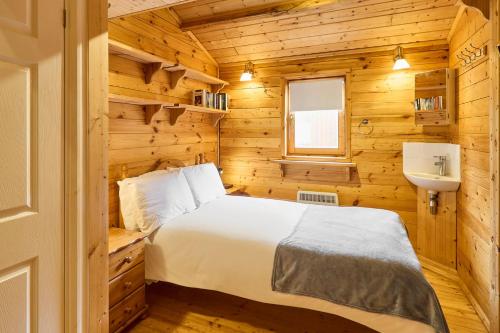 a bedroom in a wooden cabin with a bed and a sink at Host & Stay - Astoria in Broadstairs
