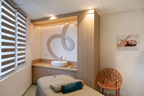 a room with a bed and a sink and a mirror at Hôtel Miléade Les Pléïades La Baule in La Baule