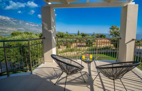 a patio with two chairs and a table on a balcony at Kefalonian Gems in Pesádha