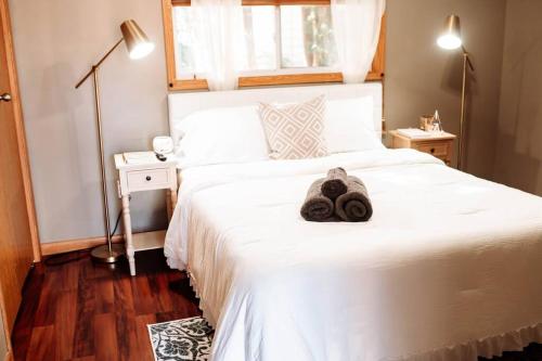 een slaapkamer met een wit bed met een knuffeldier erop bij Spacious Five-Bedroom Bliss in Fairlawn