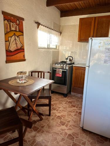 una cucina con tavolo e frigorifero di El Mirador, Apartamento a Punta Del Diablo
