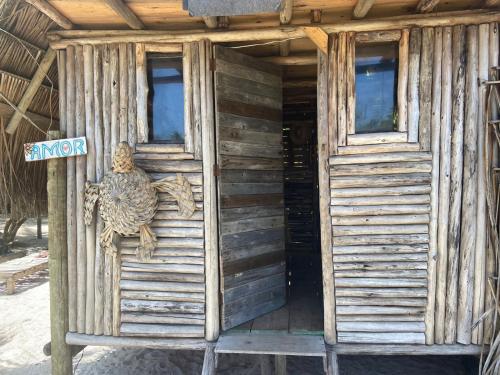 an entrance to a wooden house with a turtle on it at Cabana família coruja in Camaçari
