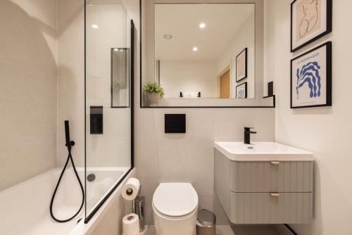 ein Bad mit einem WC, einem Waschbecken und einer Dusche in der Unterkunft The Wembley Hideout - Stylish 2BDR Flat with Balcony in London