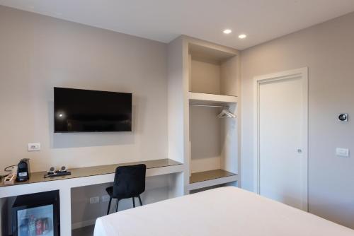 a bedroom with a bed and a tv on a wall at Il Pumo - Apulian Rooms Bari Savoia in Bari
