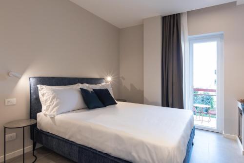 a bedroom with a large white bed with a window at Il Pumo - Apulian Rooms Bari Savoia in Bari