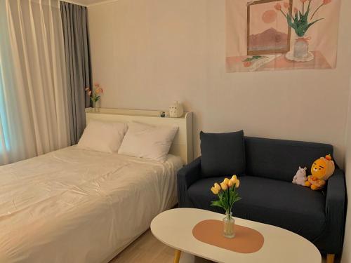 ein Schlafzimmer mit einem Bett, einem Sofa und einem Tisch in der Unterkunft Damso stay in Seoul