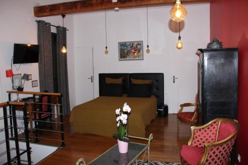 a bedroom with a bed and a table with flowers at PARIS de FLORE Flore in Malakoff