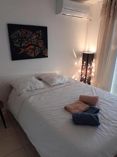 une chambre avec un lit blanc avec deux serviettes dessus dans l'établissement Appartement T2, climatisé, wifi, parking et piscine privés, à Sète