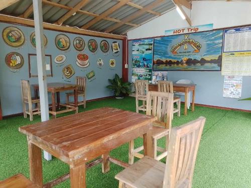 a dining room with tables and chairs and a hot trip wall at BaanPhong Lanta in Ko Lanta