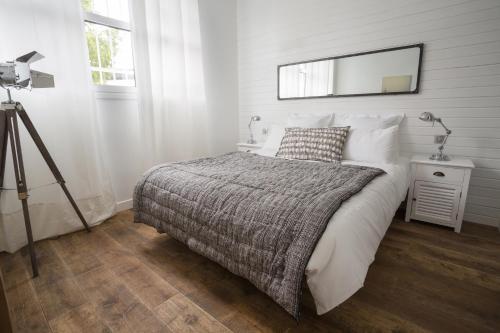 une chambre avec un lit et un miroir au mur dans l'établissement Studio Photo face au Parc des Expositions, à Paris