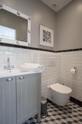 une salle de bain blanche avec un lavabo et des toilettes dans l'établissement Studio Photo face au Parc des Expositions, à Paris