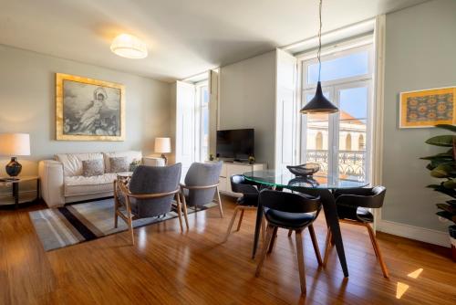 a living room with a table and chairs at Chiado Camões Apartments | Lisbon Best Apartments in Lisbon