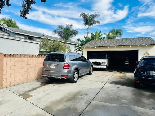 een auto geparkeerd op een oprit voor een garage bij sunny house2 in Covina