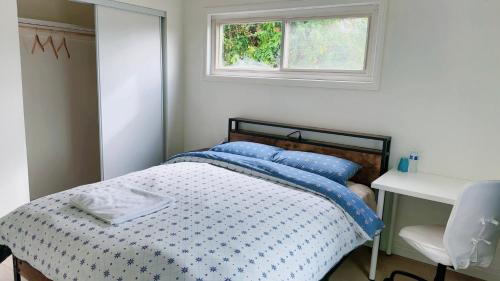 een slaapkamer met een bed met blauwe kussens en een raam bij sunny house2 in Covina