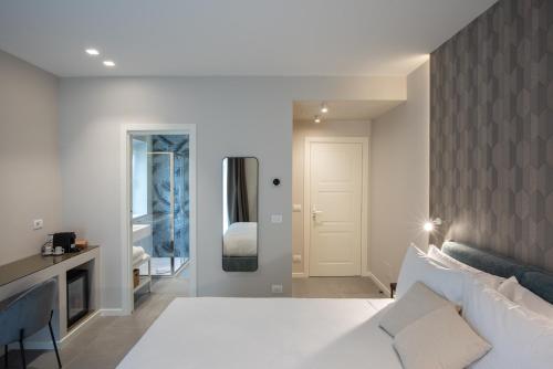 a bedroom with a white bed and a mirror at Il Pumo - Apulian Rooms Bari Savoia in Bari