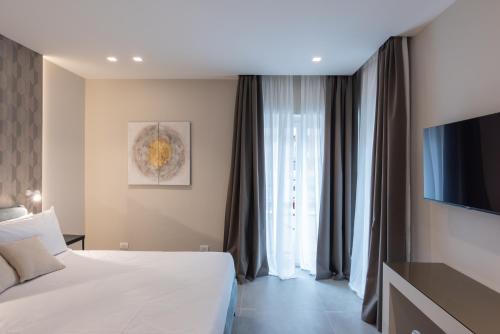 a hotel room with a bed and a television at Il Pumo - Apulian Rooms Bari Savoia in Bari