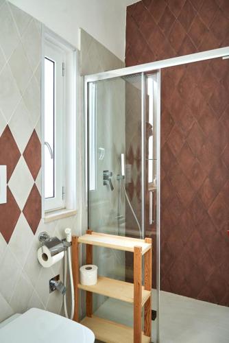 a bathroom with a shower and a toilet and a sink at Madama B&B in Gaeta