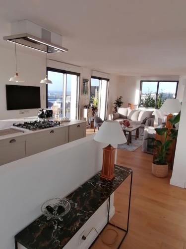 une cuisine et un salon avec un canapé et une table dans l'établissement Magnifique maison-Vue mer exceptionnelle., à Audierne