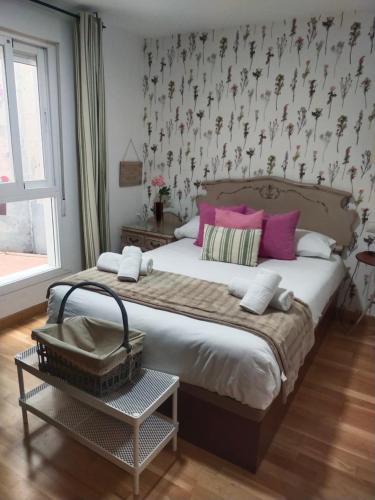 une chambre avec un grand lit avec des oreillers roses dans l'établissement CENTRO ANTEQUERA Moderno Apartamento de Santa Cruz, à Antequera