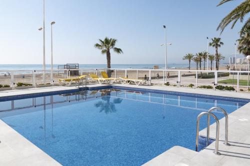 a swimming pool with the beach in the background at Florazar 3, 3-C in Cullera