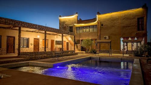 una casa con piscina di fronte a un edificio di Palais Ksar Lamane a Aït Ben Haddou