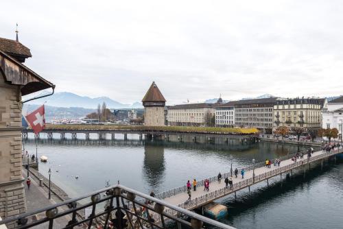 un grupo de personas caminando por un puente sobre un río en Altstadt Hotel Magic Luzern en Luzern