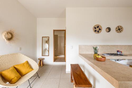 a kitchen with white walls and a counter with yellow pillows at Bahía Sirenas in Puerto Escondido