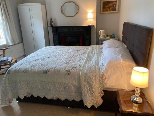 a bedroom with a bed and a table with a lamp at St Jude's Bed & Breakfast in Dersingham